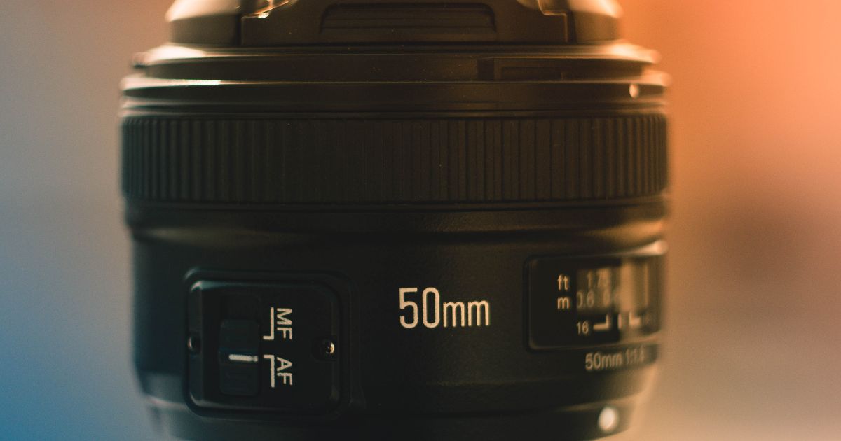 Photography For Beginners (How To Take Pictures Like A Pro) A Close Up Of A Camera Lens With A Blurred Background, Perfect For Beginners In Photography.