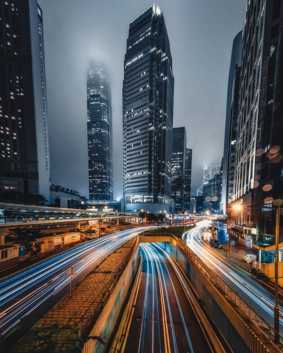 What Is Shutter Speed In Photography? (The Complete Guide) Captivating Hong Kong Cityscape At Night Illuminated By Speeding Car Lights, Showcasing The Art Of Capturing Motion Through The Optimal Use Of Shutter Speed In Photography.