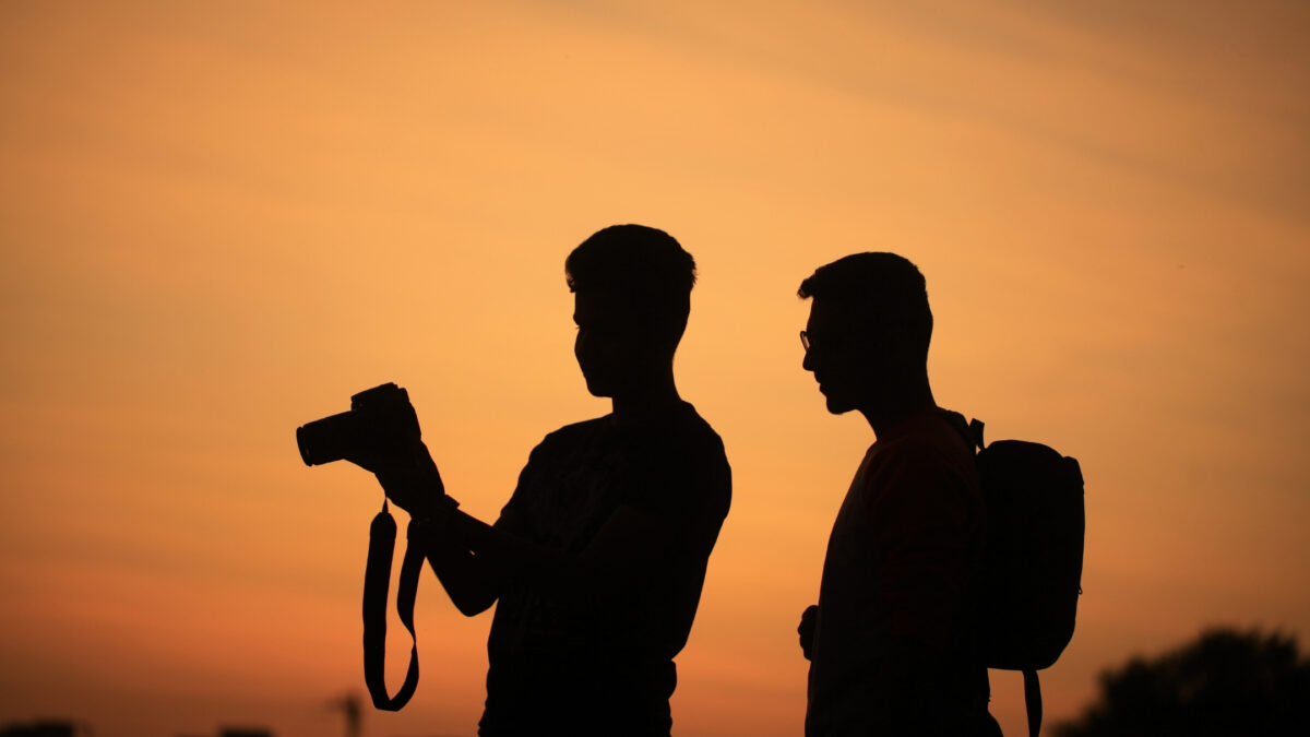 How To Join Photography Groups You'Ll Love Silhouette Of Two Men Capturing Stunning Sunset Photos.