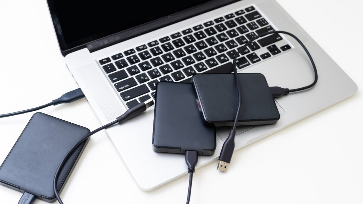 How To Store And Backup Photos Safely A Laptop Equipped With Two External Hard Drives For Storing And Backing Up Photos.