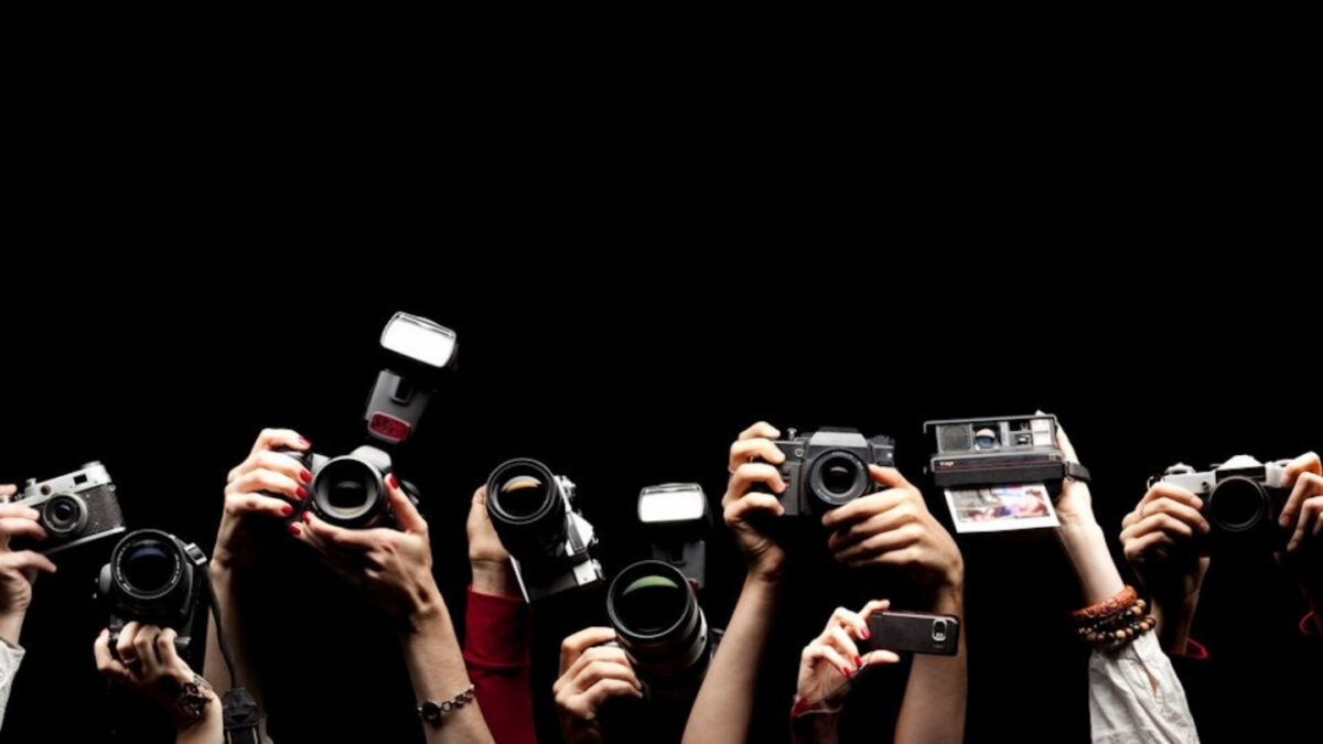 How To Join Photography Groups You'Ll Love Join A Group Of Photographers In Front Of A Black Background, Capturing Memorable Shots With Their Cameras.