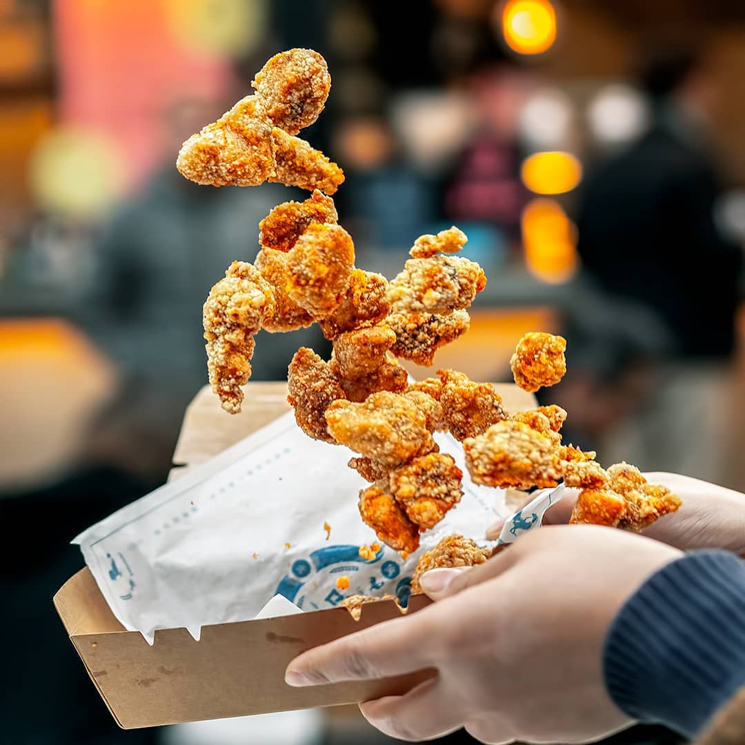 What Is Shutter Speed In Photography? (The Complete Guide) A Person Holding A Box Of Fried Chicken While Adjusting The Shutter Speed For A Perfect Food Photography Shot.