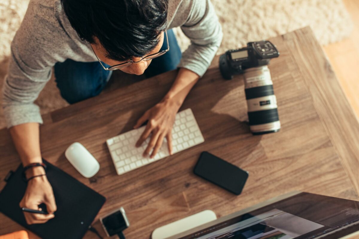 Photo Editing For Beginners (Made Easy) A Man Working At A Desk With A Laptop, Performing Photo Editing For Beginners.