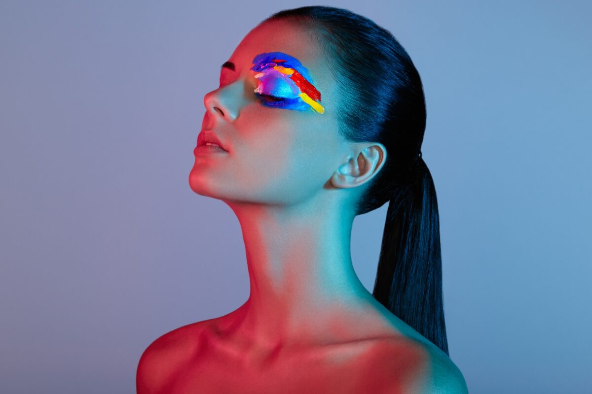 What To Say To Clients During A Photo Session: With Prompts A Woman With Vibrant Makeup On Her Face Striking Various Poses During A Photo Session.
