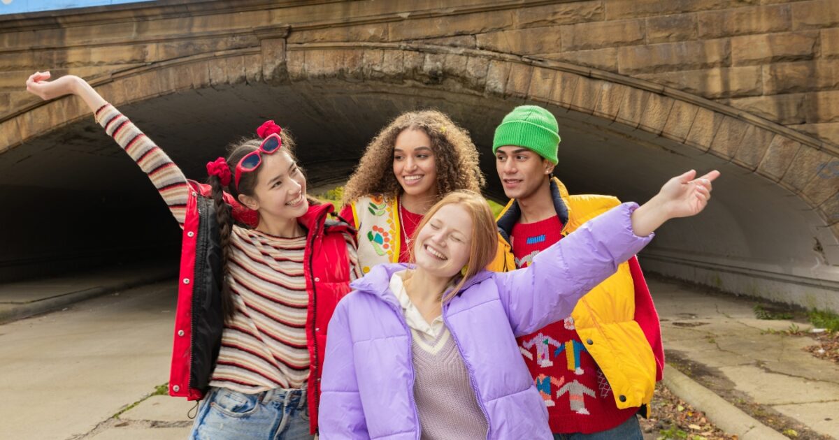 What To Wear To A Photoshoot (The Ultimate Guide) A Group Of Young People Standing In Front Of A Tunnel Wearing A Lot Of Colorful Clothes That Doesn'T Match One Another.