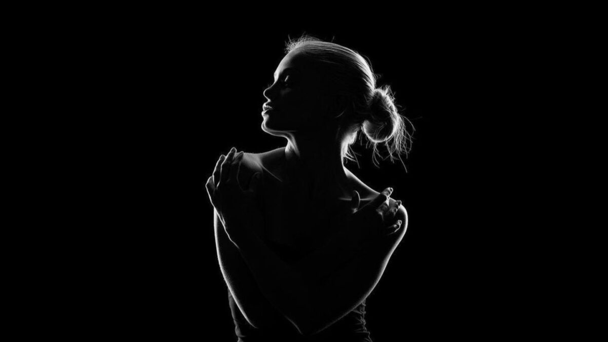 Shadow Photography (Tips And Secrets You Need To Know) A Shadow Photography Of A Woman On A Black Background.