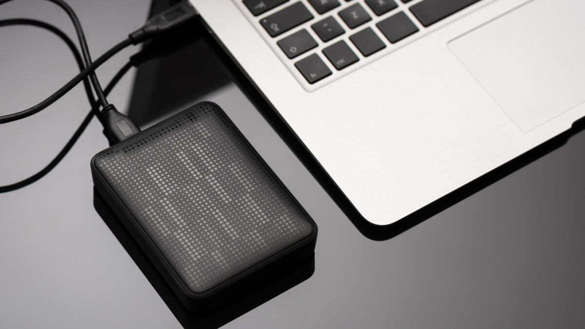 How To Store And Backup Photos Safely A Solar Charger Conveniently Placed Next To A Laptop On A Table.