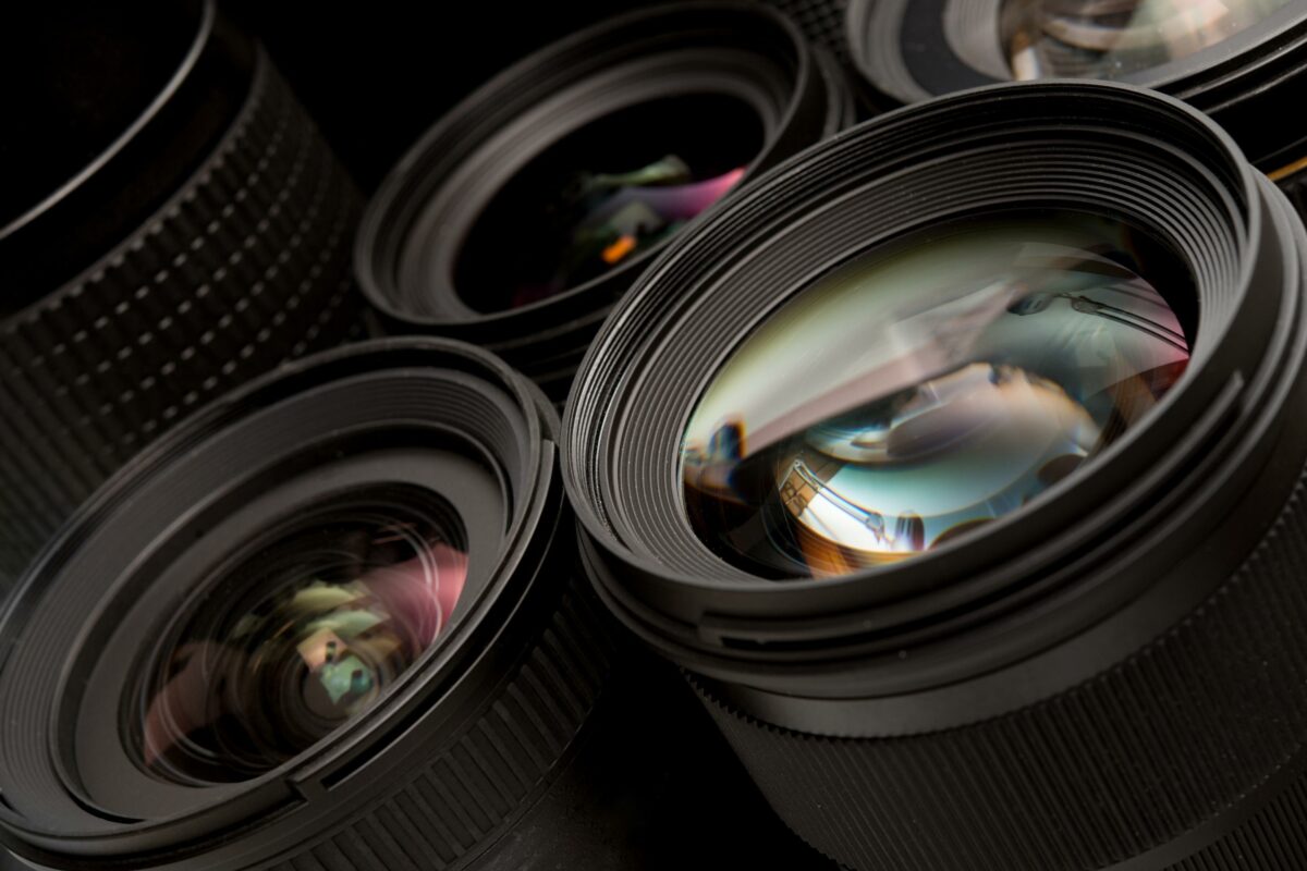 12 Mistakes Photographers Make A Collection Of Camera Lenses On A Black Background, Highlighting Common Mistakes Photographers Make.