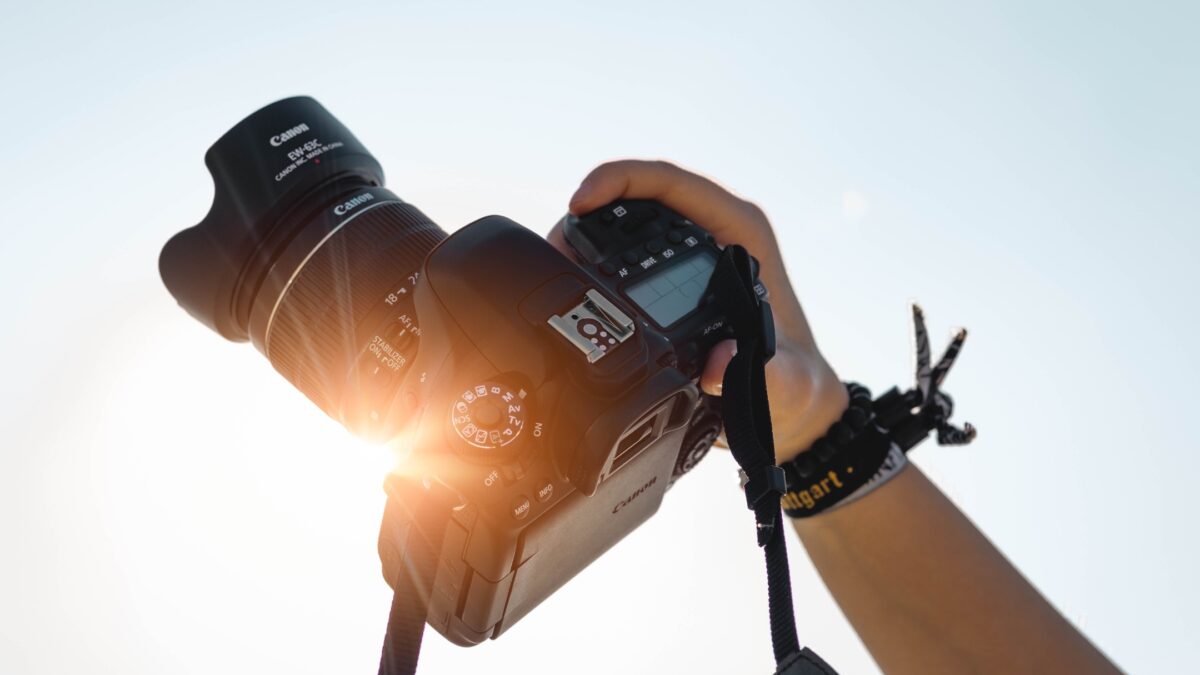 How To Learn And Improve From Mistakes As A Photographer A Person Holding A Dslr Camera With The Sun Behind It, Capturing Moments And Learning From Mistakes As A Photographer.