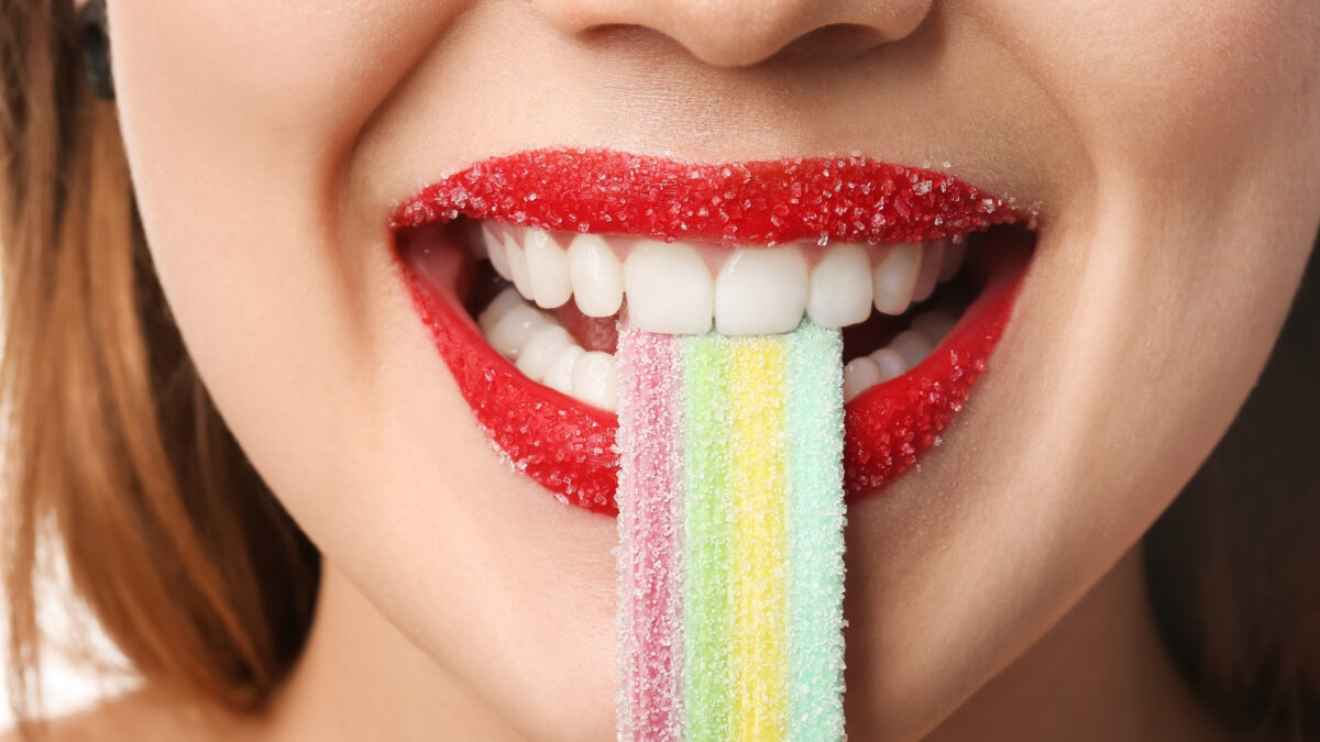 Props To Bring To A Photoshoot That'Ll Make Your Photos Pop Props To Bring To A Photoshoot: A Woman Is Holding A Colorful Gummy Stick.