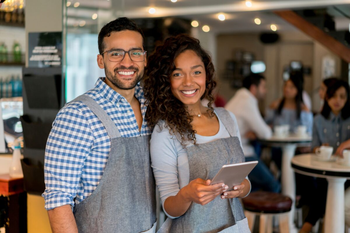 Why Photography Is Important In Business And Life A Smiling Couple In A Restaurant Enjoying Their Meal While Holding A Tablet.