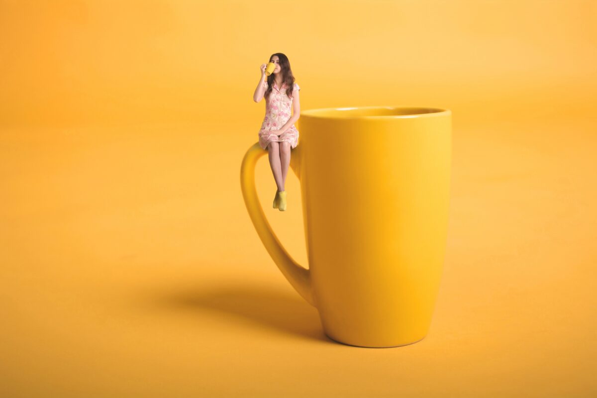 How To Turn Photos Into Art A Girl Sitting On Top Of A Yellow Coffee Cup While Turning Photos Into Art.