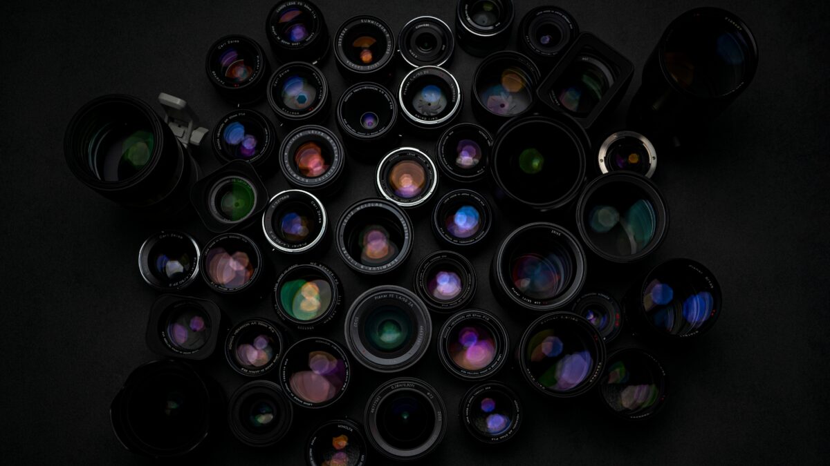 Photography Equipment List: What You Need To Make The Perfect Camera Bag A Group Of Camera Lenses From A Photography Equipment List On A Black Background.