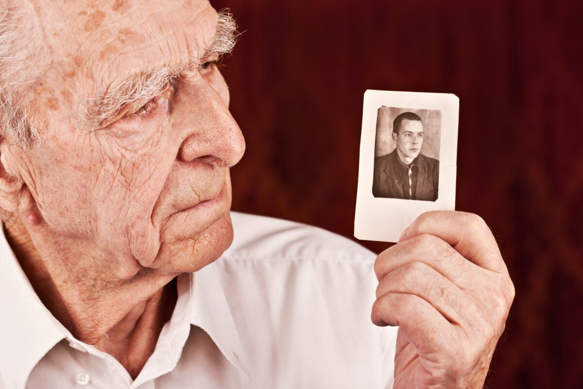 Why Photography Is Important In Business And Life An Elderly Man Is Showcasing The Significance Of Photography By Holding Up A Photo Of An Old Man.