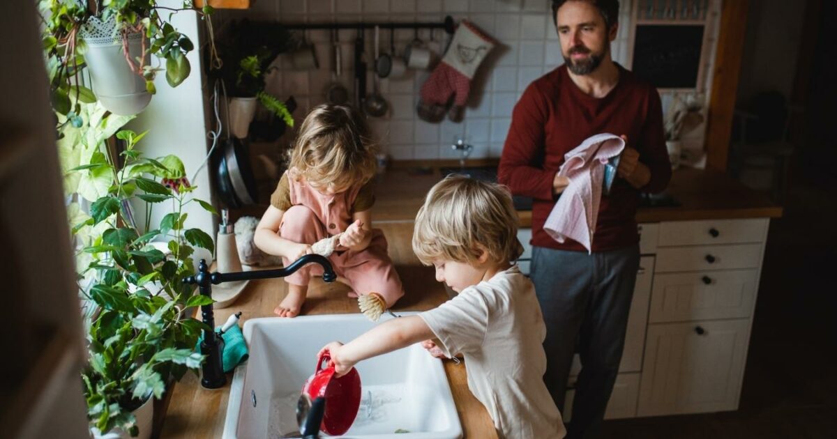 What Is A Photo Essay In Photography (13 Examples You Can Try) A Photo Essay Depicting A Man And Two Children Engaging In Dishwashing Activities Within A Kitchen Environment.