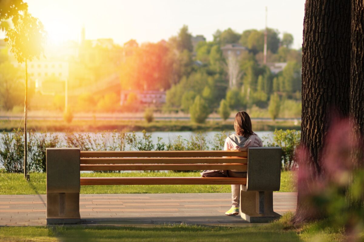 Composition In Photography And What You Need To Know A Woman Sitting On A Bench, Beautifully Captured In A Composition In Photography.