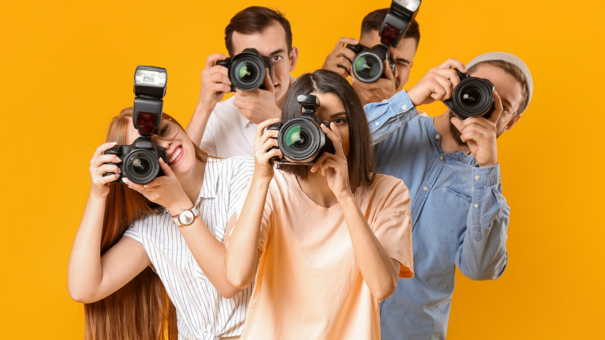 How To Join Photography Groups You'Ll Love Individuals From Various Photography Groups Capturing Moments With Their Cameras Against A Vibrant Yellow Backdrop.