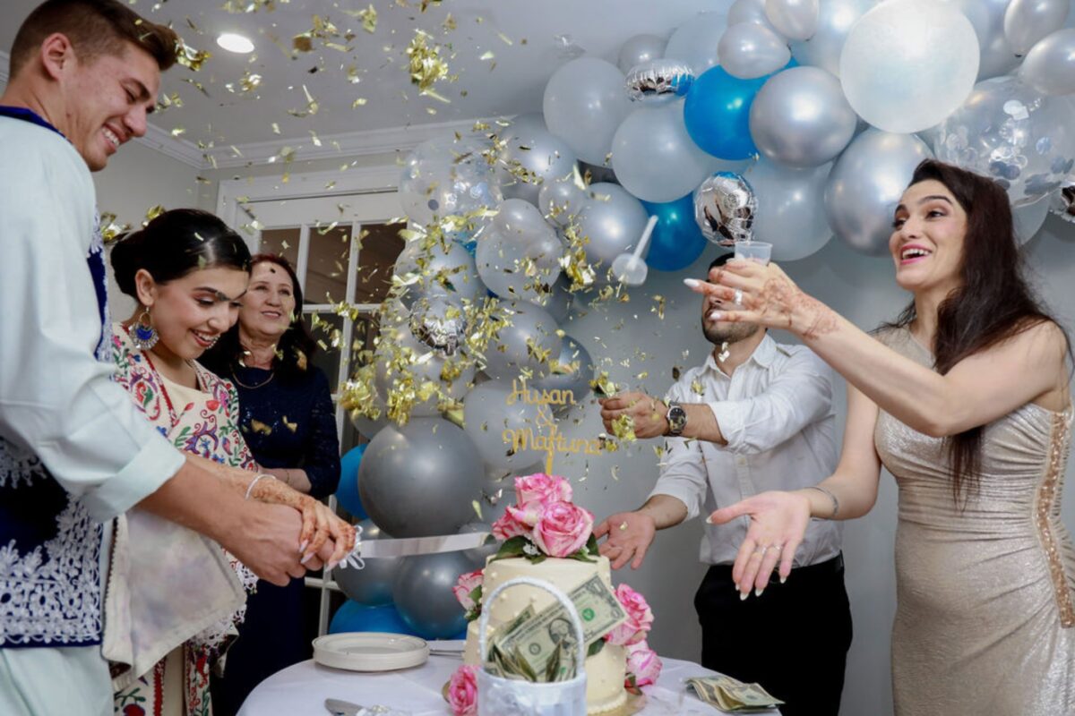 Auto Vs. Manual Mode: What Photographers Should Know A Group Of People Cutting A Cake In Front Of Balloons.