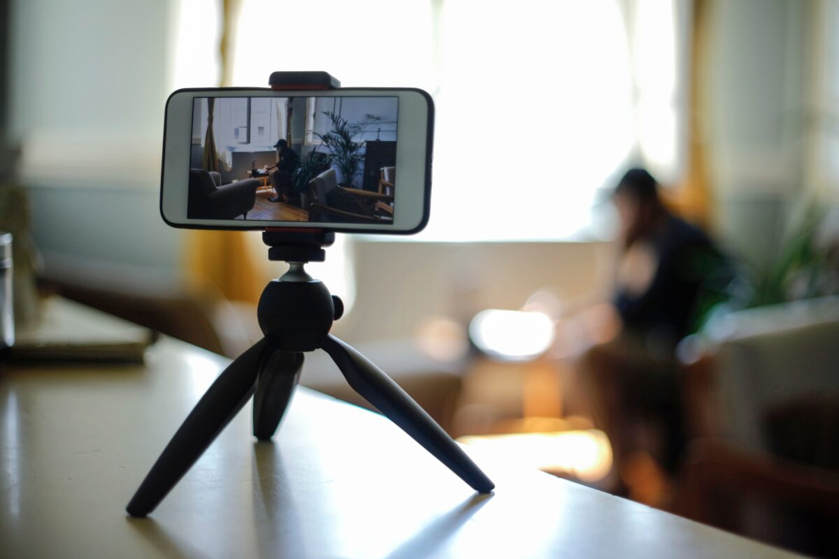 Mobile Photography Tips That'Ll Help You Take Better Photos A Person Utilizing Mobile Photography Tips While Using A Cell Phone On A Tripod.