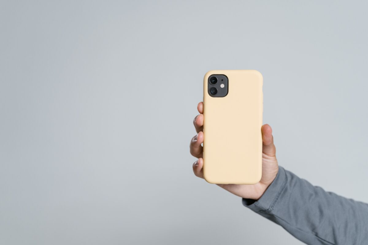 Mobile Photography Tips That'Ll Help You Take Better Photos A Person Showcasing Mobile Photography Tips By Holding Up A Yellow Iphone Case Against A Sleek Gray Background.