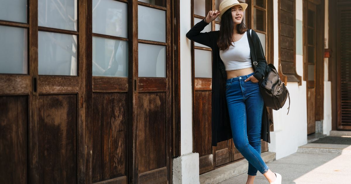 Best Photography Poses For Pictures (From A Pro Photographer) Asian Woman Poses For Pictures Leaning Against A Wooden Wall.