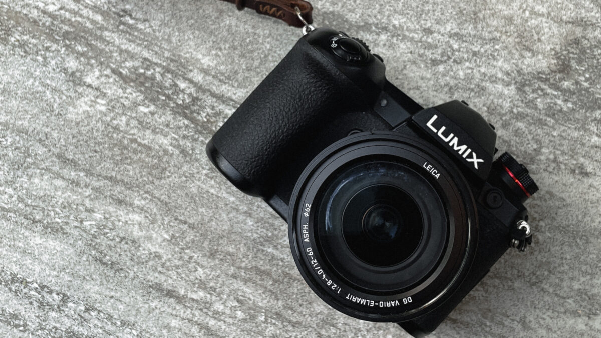 Dslr Vs. Mirrorless (What'S Best For A New Photographer?) A Black Dslr Camera With A Strap Attached To It.