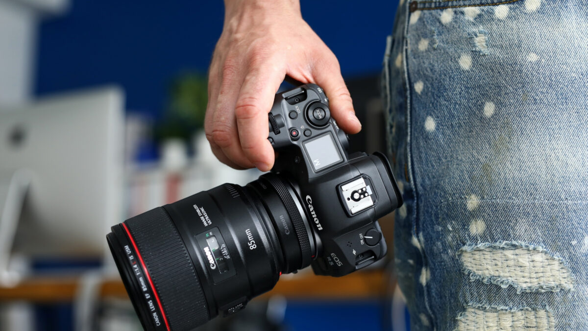 Dslr Vs. Mirrorless (What'S Best For A New Photographer?) A Person Holding A Dslr Camera In Their Jeans.