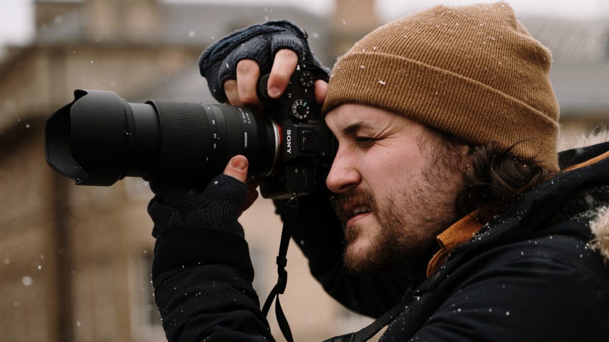 How To Learn And Improve From Mistakes As A Photographer A Man Making Mistakes As A Photographer While Holding A Camera In The Snow.