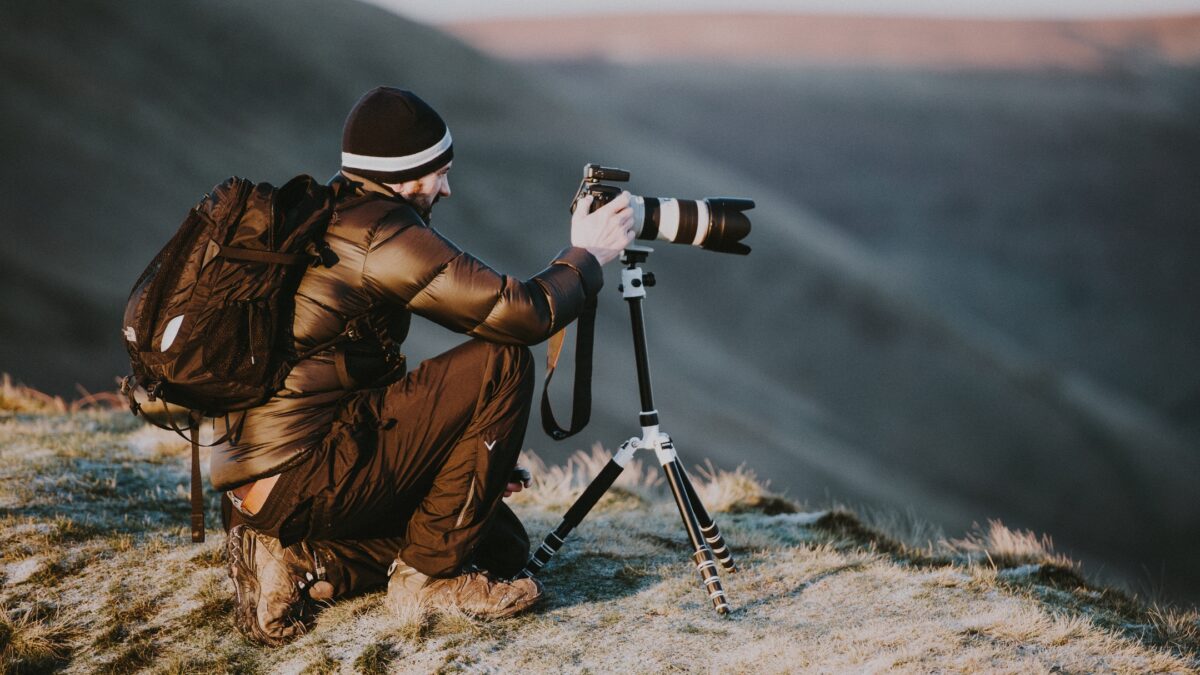 How To Learn And Improve From Mistakes As A Photographer A Man Holding A Camera On Top Of A Mountain, Learning From His Mistakes As A Photographer.