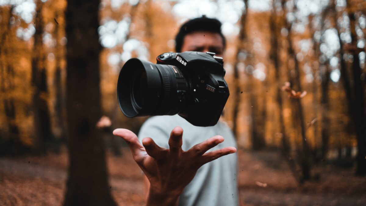 How To Learn And Improve From Mistakes As A Photographer A Man, Plagued By Mistakes As A Photographer, Holding A Camera In The Woods.