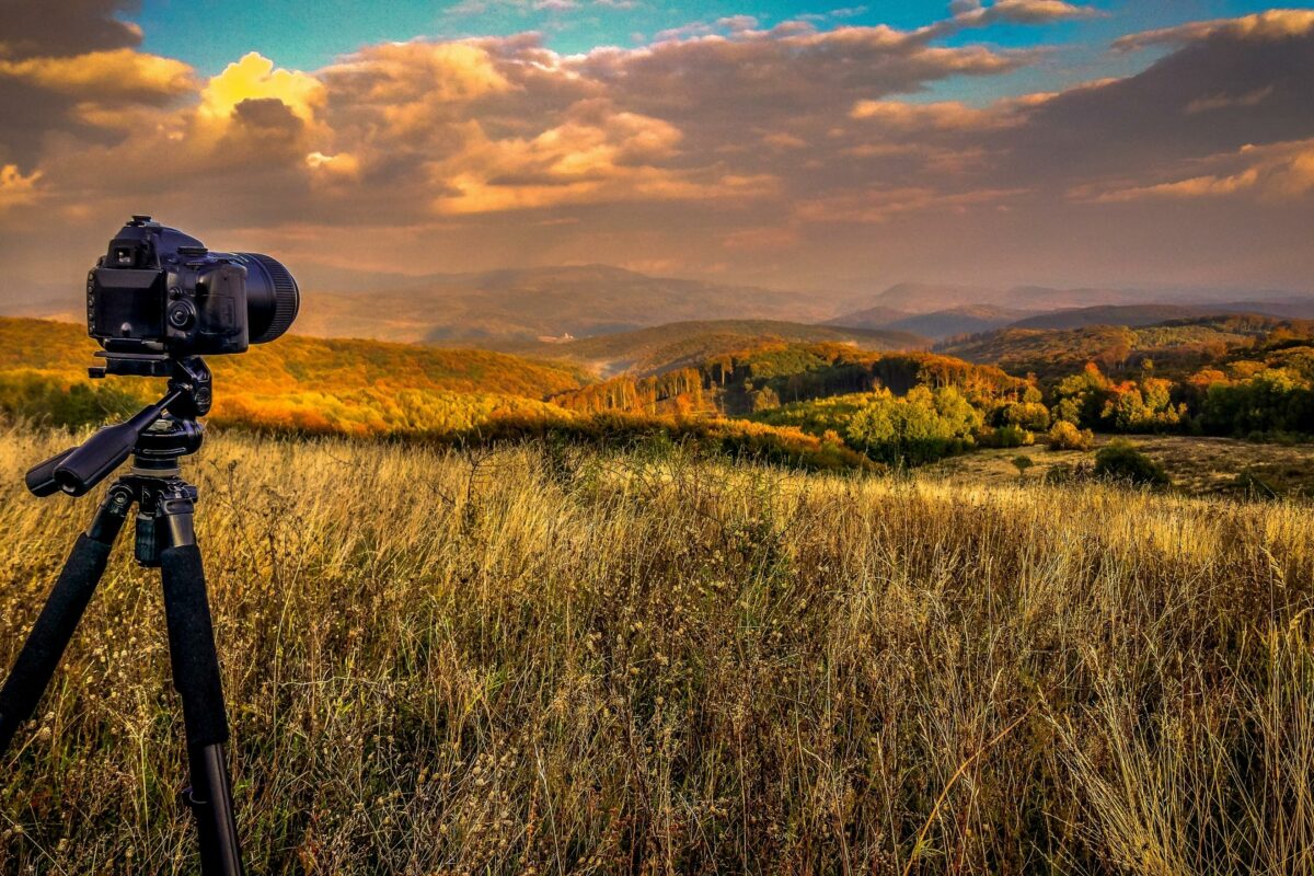 The Complete Guide To Nature Photography For Beginners A Tripod With A Camera Capturing Nature Photography In The Middle Of A Field.