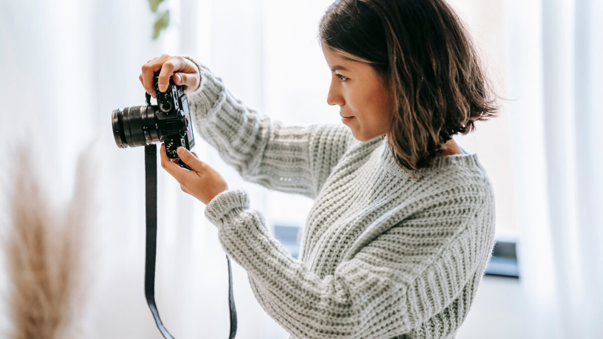 How To Get And Give Feedback On Photos As A Photographer A Woman Capturing Feedback On Photos With A Camera In Front Of A Window.