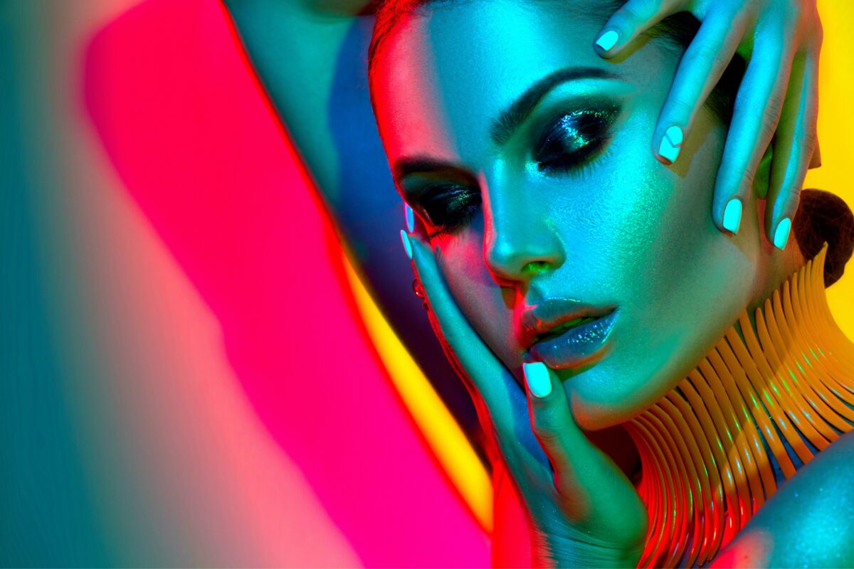 Why Photography Is Important In Business And Life A Woman Is Posing In Front Of A Colorful Background, Showcasing Why Photography Is Important.