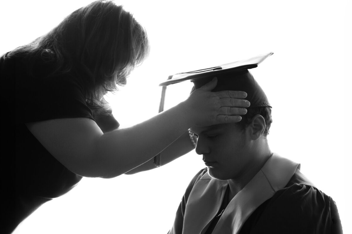 Why Photography Is Important In Business And Life A Captivating Photograph Captures The Poignant Moment Of A Woman Tenderly Placing A Graduation Cap On A Man, Highlighting The Significance Of Photography In Preserving Important Milestones.