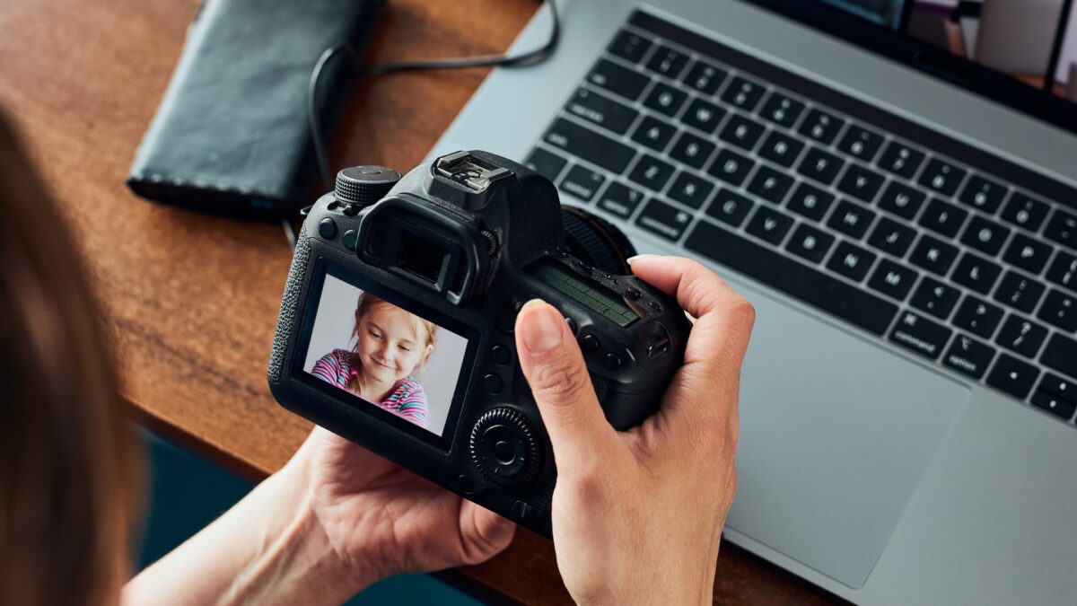 Professional Photographer Tips To Get Your First Booking A Woman Is Taking A Picture Of A Person With A Camera.