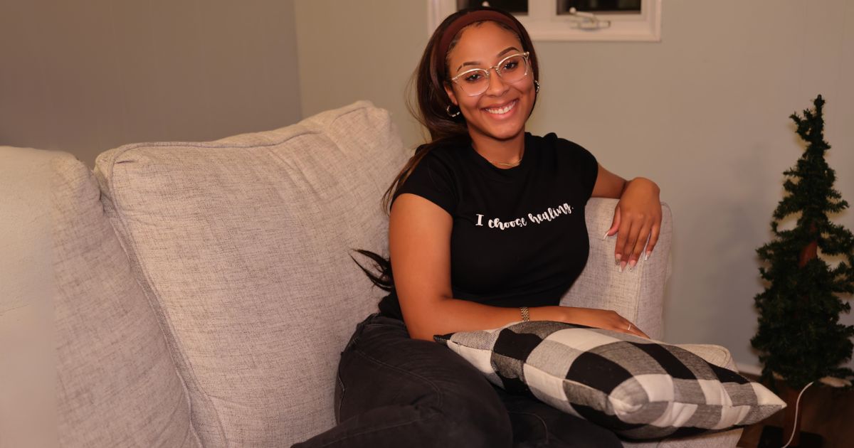 Photography At Home: Tips For Capturing Great Shots Indoors A Woman Sitting On A Couch With A Pillow In A Home Photography Session.