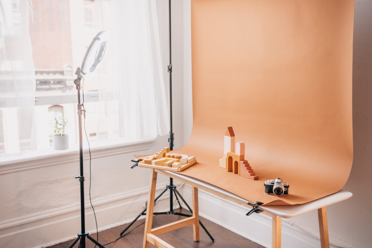 The Complete Guide To Photography Backdrops A Photography Background Featuring A Wooden Table And A Light Stand.
