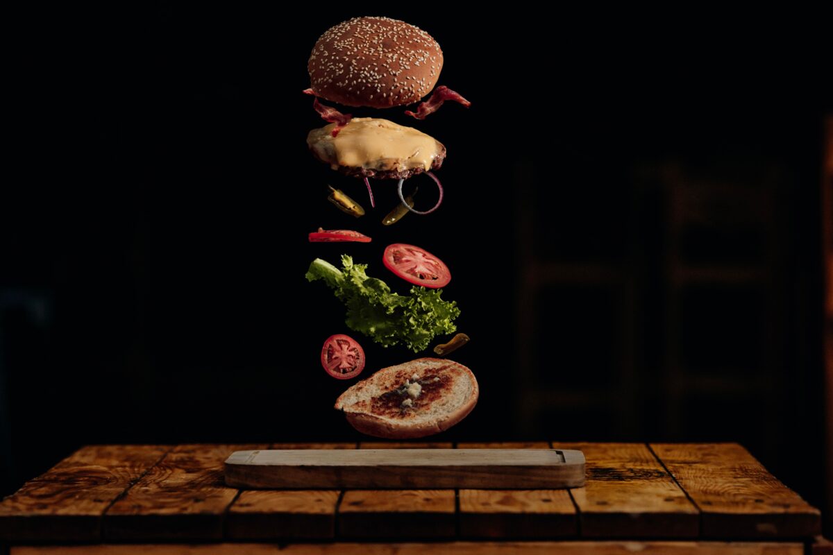 Why Photography Is Important In Business And Life An Image Capturing The Moment A Burger Falls Off A Wooden Table, Highlighting The Significance Of Photography.