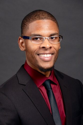 About A Black Man In Glasses And A Red Tie.