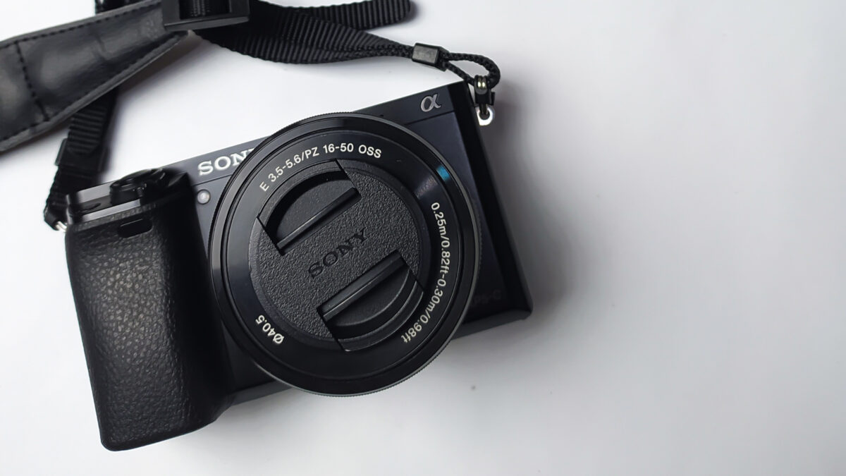 Dslr Vs. Mirrorless (What'S Best For A New Photographer?) A Black Camera With A Strap Attached To It, Available In Both Dslr And Mirrorless Options.