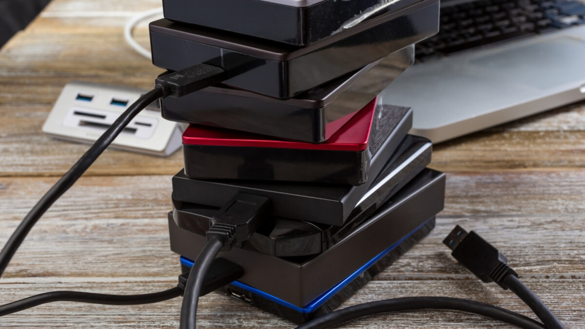 How To Store And Backup Photos Safely A Stack Of Usb Chargers Next To A Laptop, Ready To Store And Backup Photos.