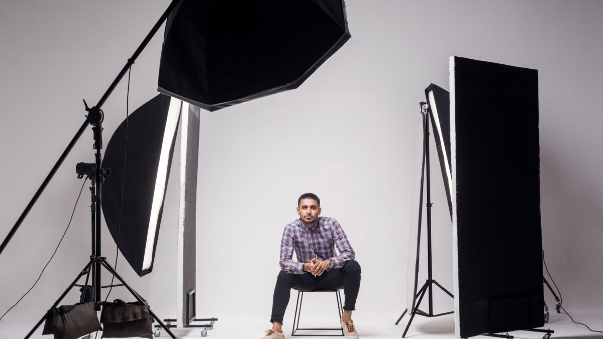 The 3 Best Photography Lighting Kits For Taking Photos A Man Sitting On A Chair In Front Of A Photography Lighting Kit.