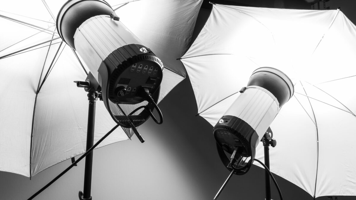 The 3 Best Photography Lighting Kits For Taking Photos A Black And White Photo Of Two Umbrellas In A Studio, Captured Using Professional Photography Lighting Kit.