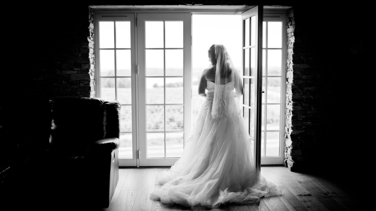 Perfect Indoor Photos And The Camera Settings You'Ll Need A Bride Is Posing For Perfect Indoor Photos In Front Of An Open Door.