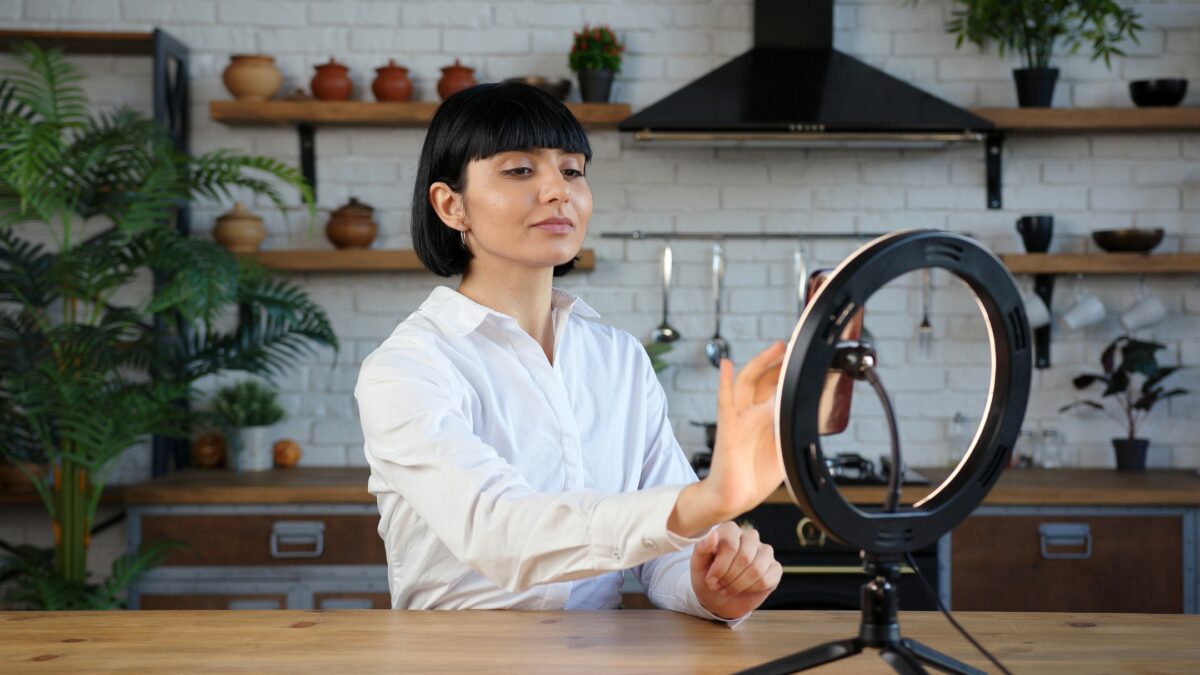 Photography Ring Light: 3 Best Choices For Content Creators A Woman Is Holding A Photography Ring Light In Front Of A Table.
