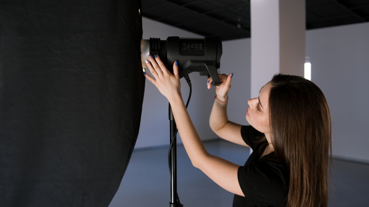 Professional Photographer Tips To Get Your First Booking Photographer Adjusting Light